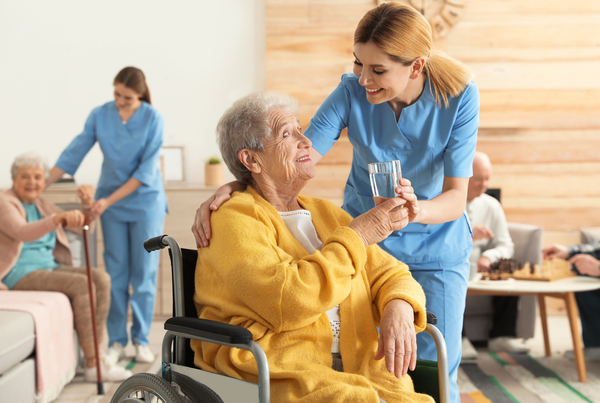 Nurse,Giving,Glass,Of,Water,To,Elderly,Woman,In,Wheelchair Zorg | Natural Mood Makers | geurmarketing